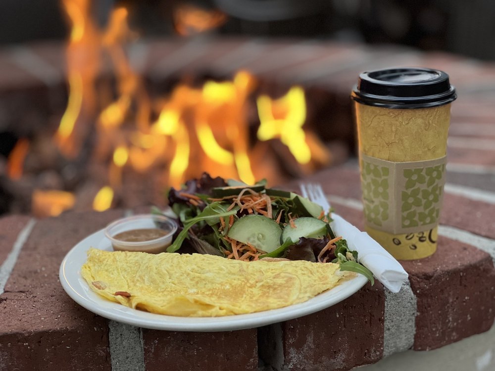 Omelet, salad and coffee beside an outdoor fire pit at Cafe Elysa