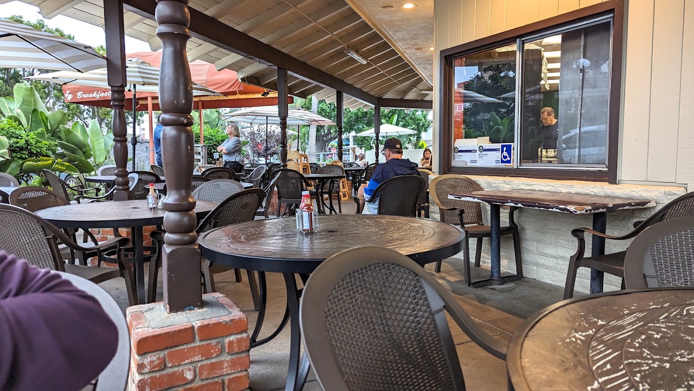 Cafe Elysa covered outdoor patio with breakfast sign and guests